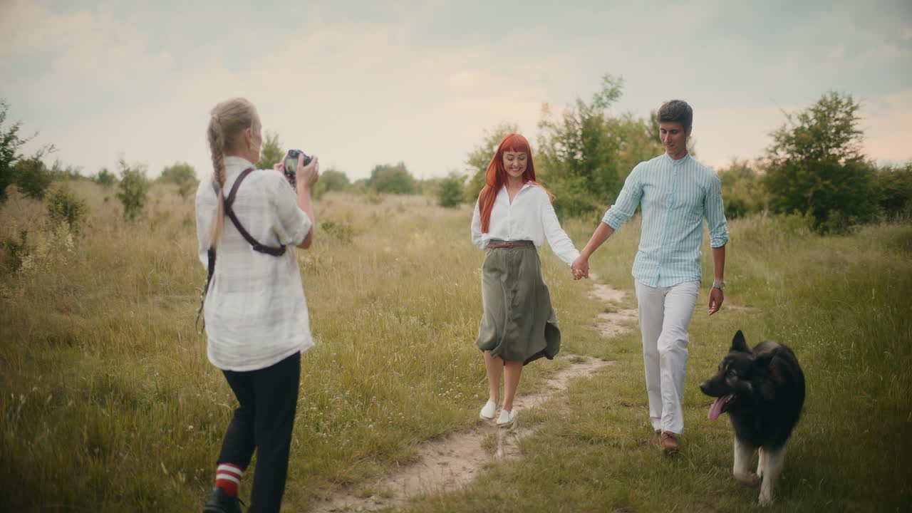 Couple Walking With Dog While Being Photographed
