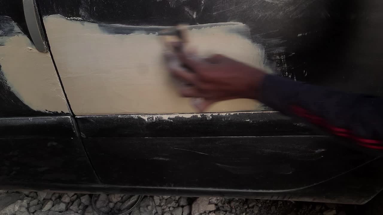 작업장이나 차고에서 자동차 금속 람비 퍼티 마찰 작업의 클로즈업 비디오 샷