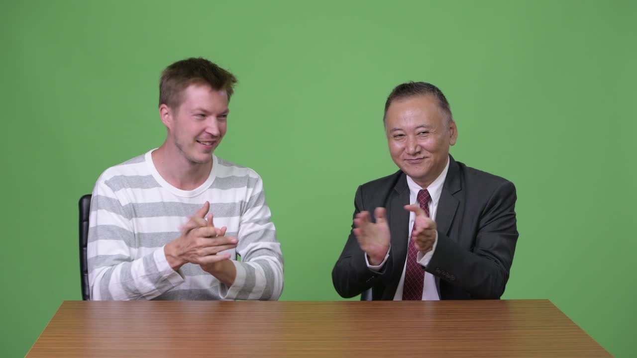 성숙한 일본 사업가와 젊은 스칸디나비아 사업가가 함께 일하고 있습니다.