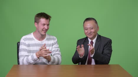 성숙한 일본 사업가와 젊은 스칸디나비아 사업가가 함께 일하고 있습니다.