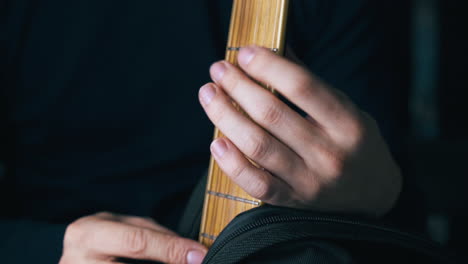 musician opens black case and puts hands on new guitar