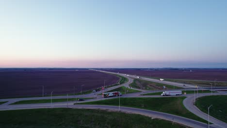 Vista-Aérea-Del-Cruce-De-Carreteras-Con-La-Policía-Deteniendo-Una-Camioneta-Al-Atardecer