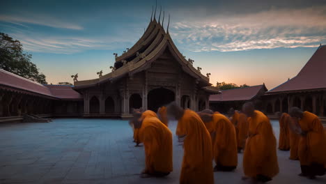 monks in a buddhist temple courtyard at sunset