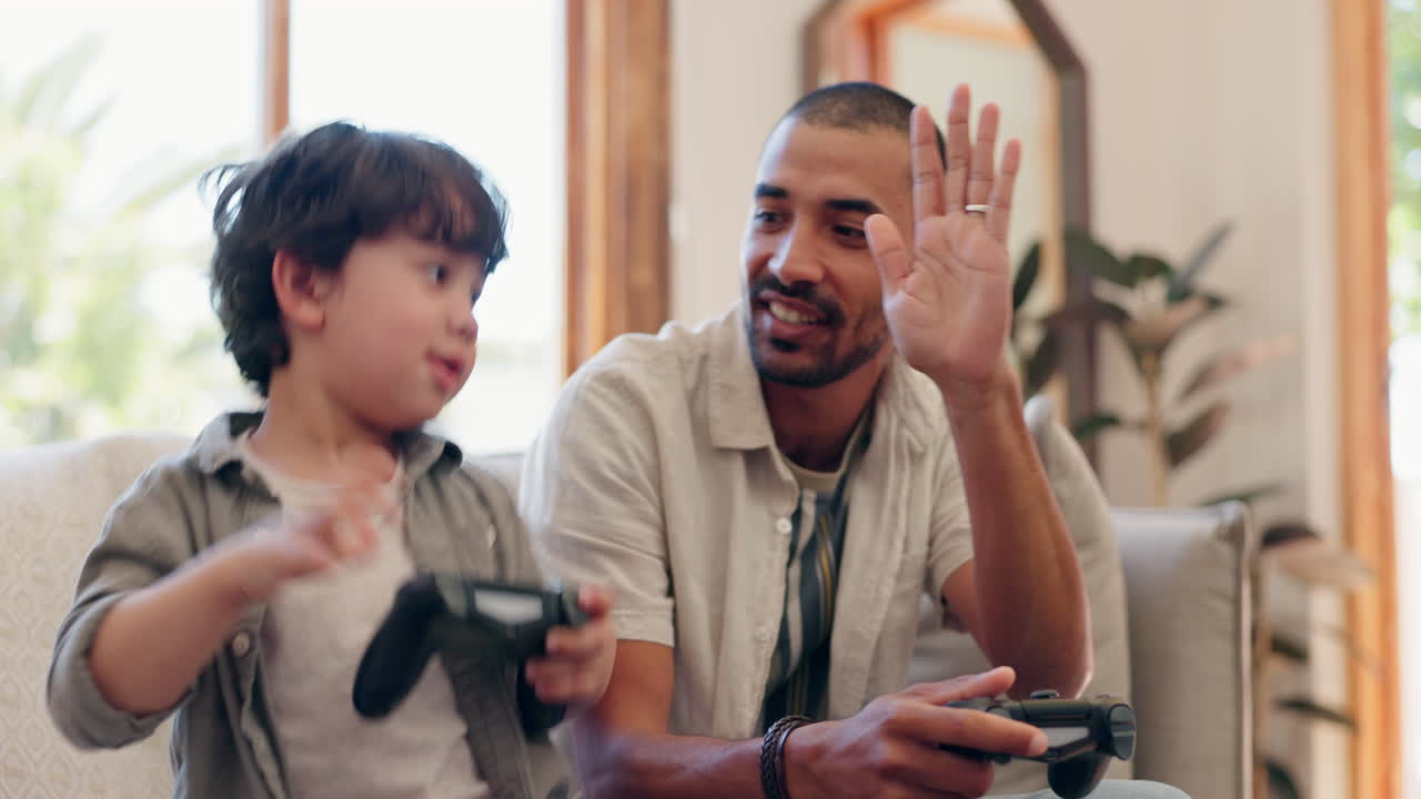 Father, son and video game with high five on sofa