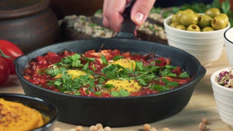 israeli cuisine. shakshuka decorated with parsley close-up. national jewish dish made of eggs fried in tomato sauce, hot peppers, onions and spices, middle eastern culture, chakchouka