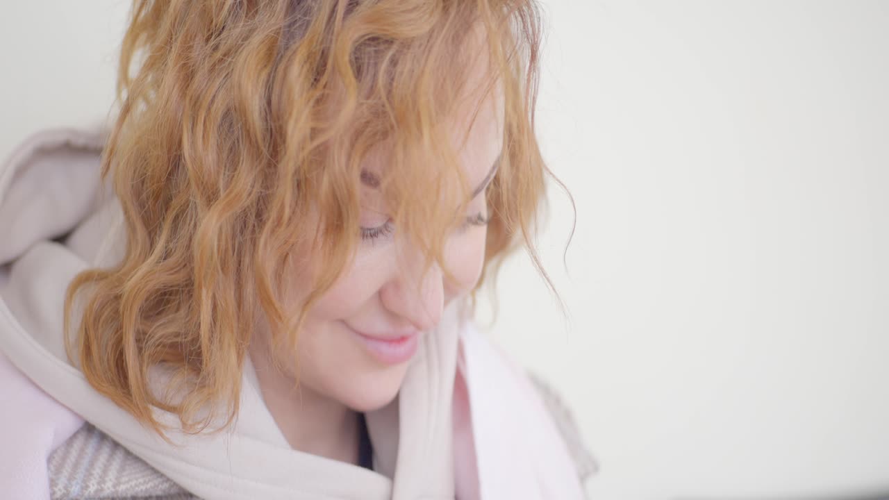 후디를 입은 곱슬 빨간 머리카락을 가진 여자