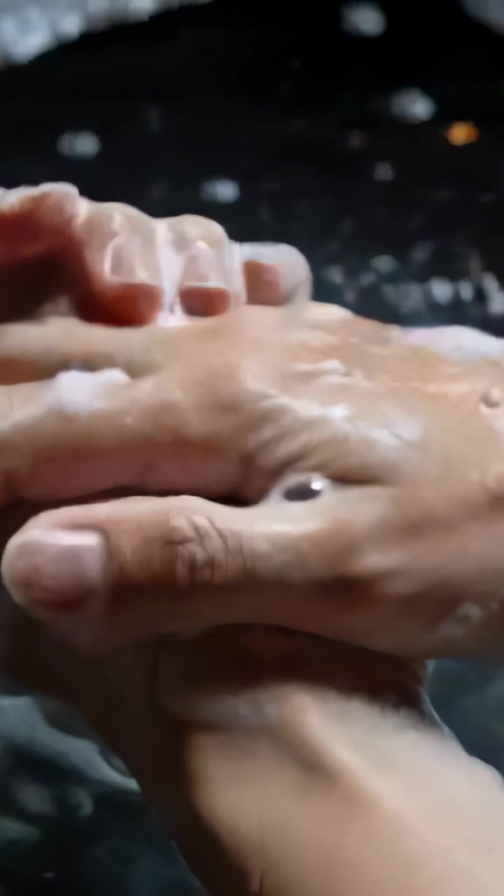 Video verticale: Iniziando con il sapone nei palmi, mani adulte che insaponano e strofinano al lavandino, con schiuma.