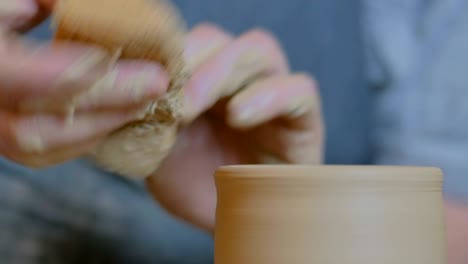 professional potter shaping pot in pottery workshop