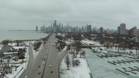 cars driving along lake share drive towards downtown chicago, illinois on a gloomy winter day
