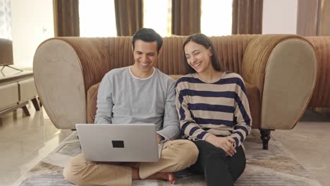 indian couple planning something and typing on laptop