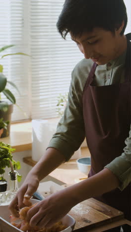 teenage boy cooking chicken in the kitchen
