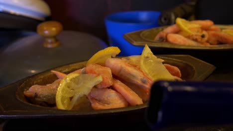 Handheld-Close-Up-Shot-of-Hand-Putting-Lemons-onto-Some-Frozen-Shrimps-Which-is-Being-Prepared-For-The-Oven-for-a-Delicious-Cajun-Dish