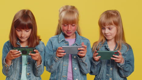 Three-girls-friends-playing-racing-or-shooter-online-video-games-on-smartphone-drive-simulator-app