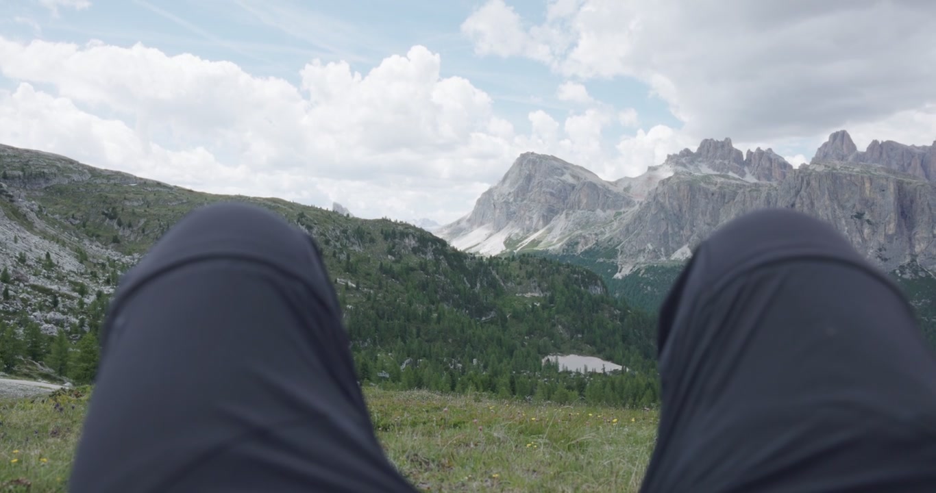 Hiker Relaxing With A View Of The Limestone Spires In The Dolomites Mountain Range In Italy. - POV shot