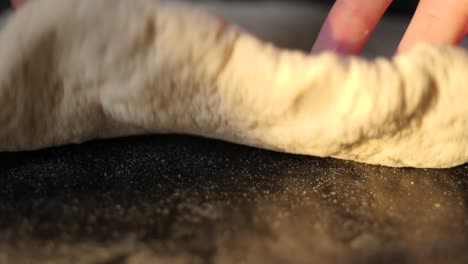 unique extreme close-up of pizza dough being rolled out towards the camera