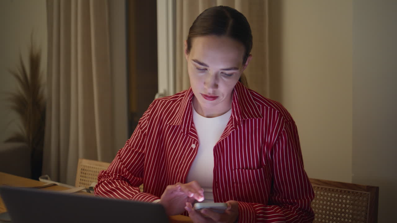 Girl multitasking home office texting smartphone. Remote businesswoman working