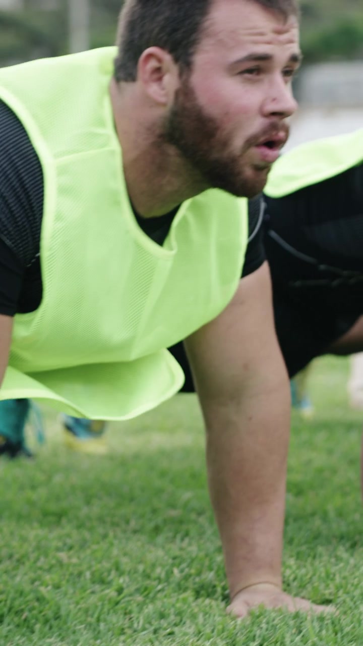 Giocatori di rugby che fanno flessioni durante una sessione di allenamento all'aperto