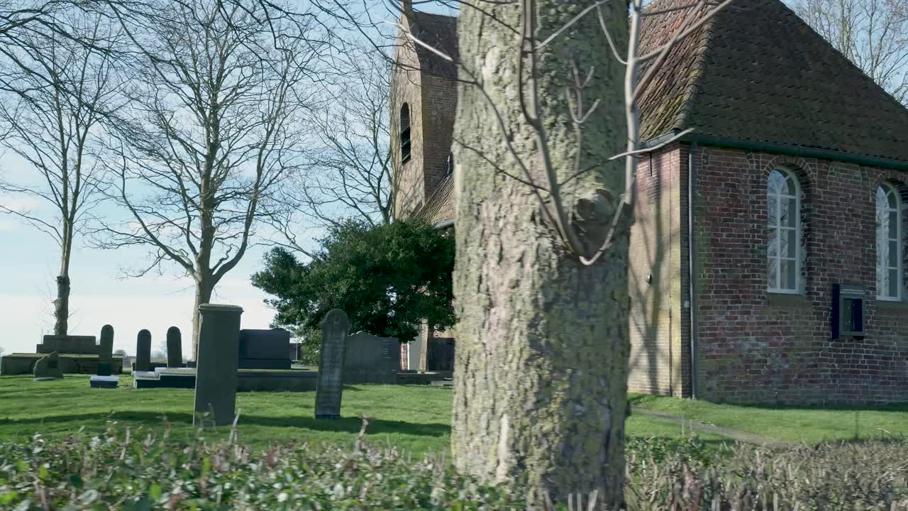 Oude bakstenen kerk en begraafplaats op het platteland op een zonnige dag