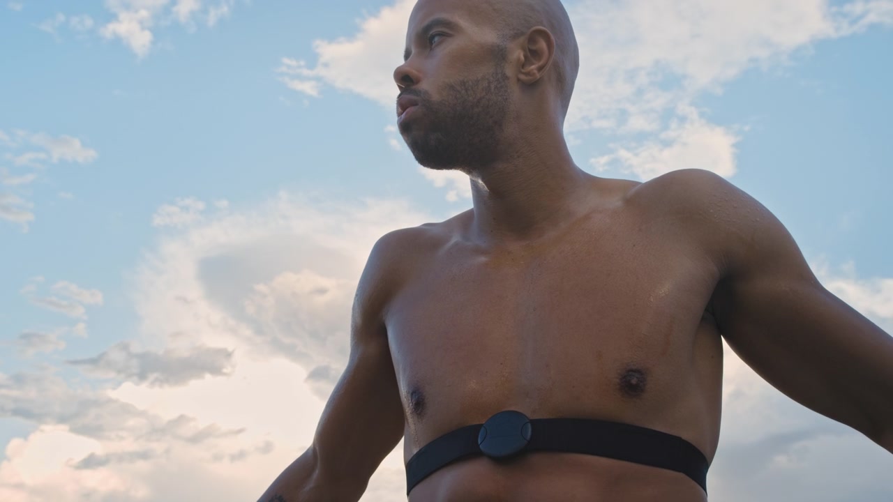 Atleta sudato con cardiofrequenzimetro che si riposa dopo l'allenamento