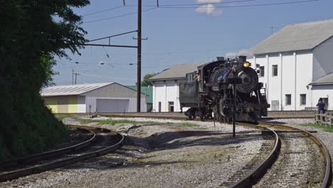 antique steam locomotive traveling around a bend on a spur