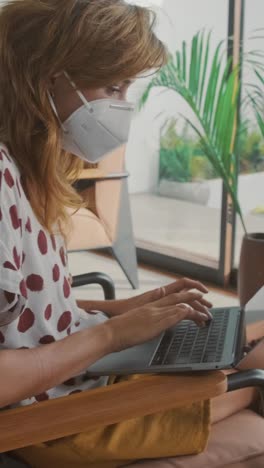 young woman working on laptop in modern indoor setting