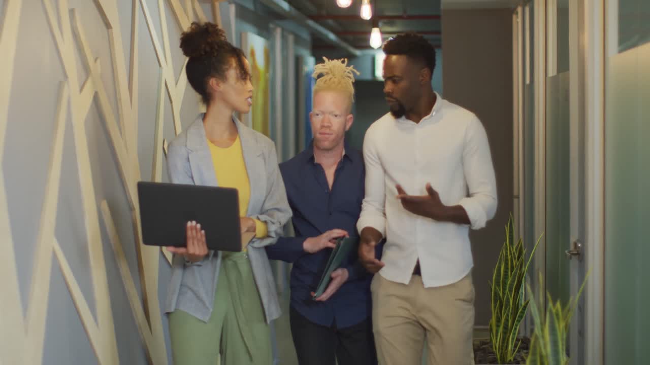 diversas personas de negocios discutiendo con computadora portátil y caminando en la oficina creativa