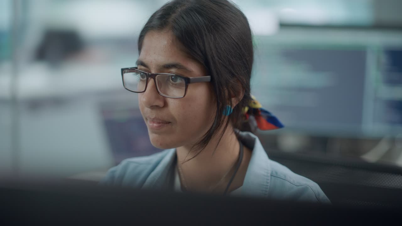 oficina diversa: retrato de un programador de ti indio confiado que trabaja en una computadora de escritorio. especialista femenina que usa gafas crea software innovador. ingeniero profesional desarrolla una aplicación inspiradora