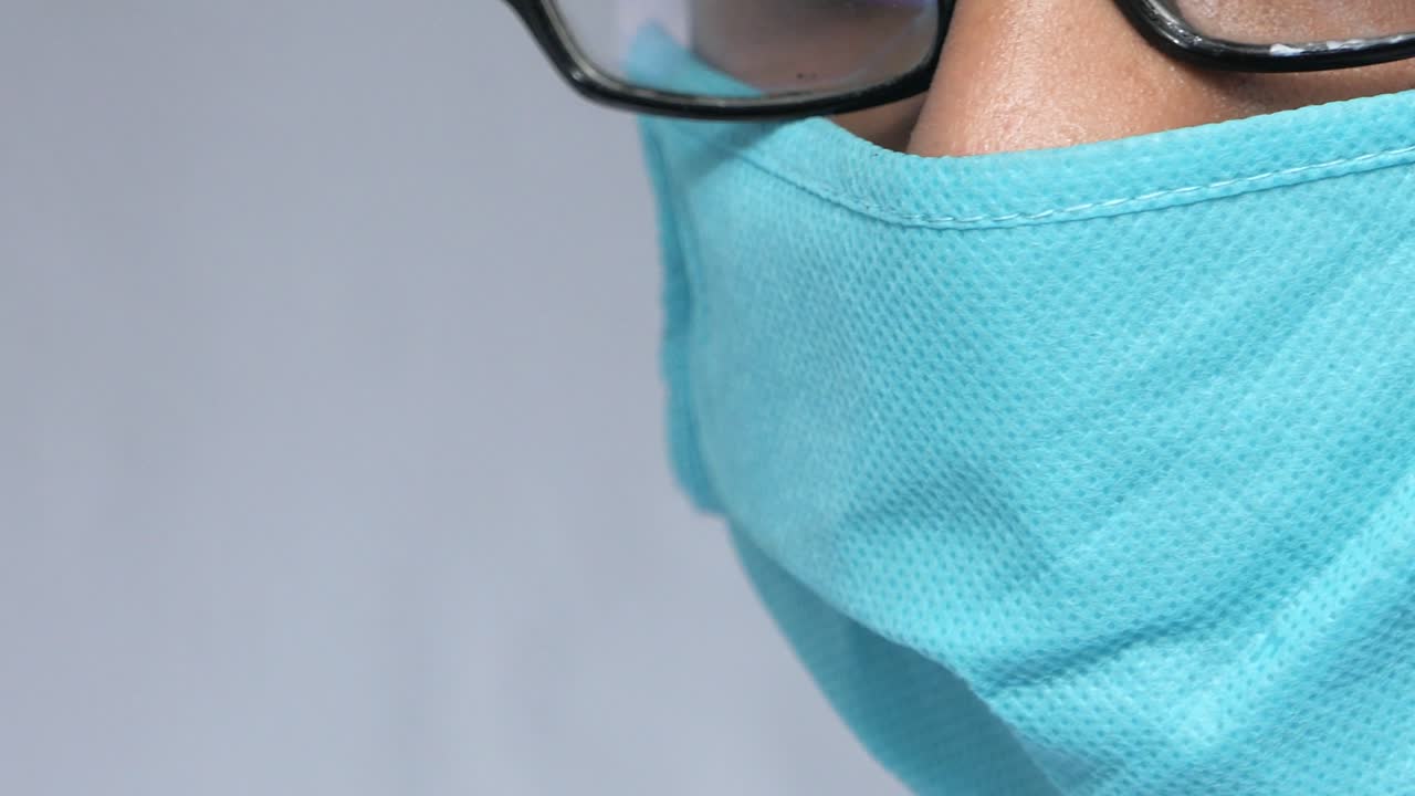 persona con una máscara facial azul y gafas