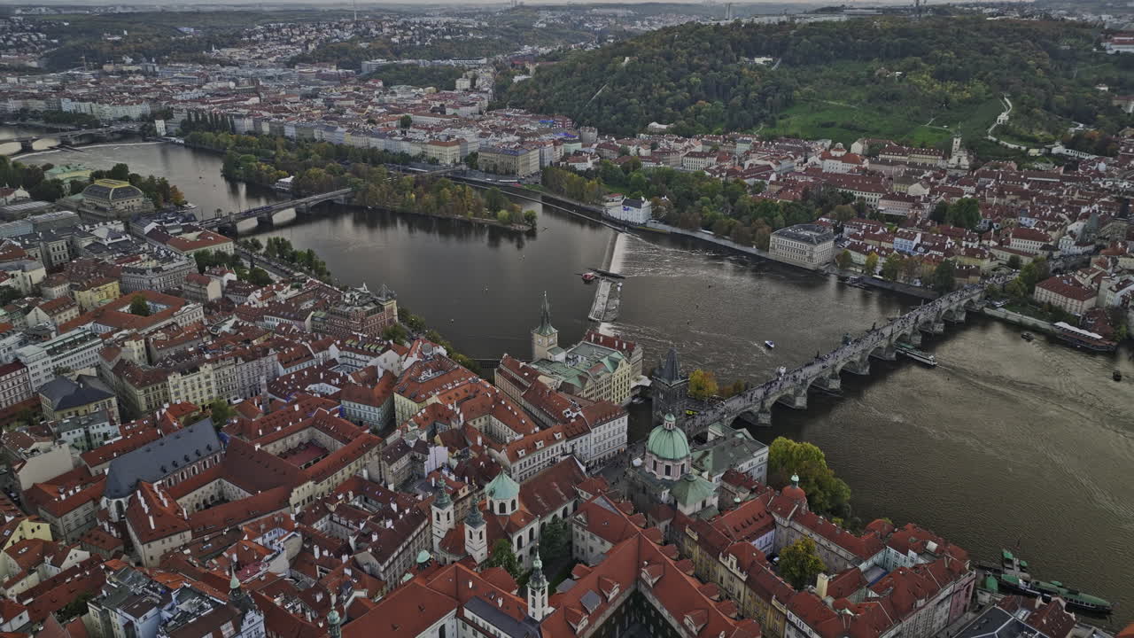 Praga, Cechia. Veduta aerea v83 a volo d'uccello, sorvolo inverso con drone del quartiere della Città Vecchia, lontano dal punto di riferimento Ponte Carlo, che cattura l'intero paesaggio urbano lungo il fiume Moldava. Ripreso con Mavic 3 Cine - Novembre 2022.