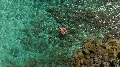 Girl-in-Swimming-Tire---Drone-Fly-Up---in-the-sea