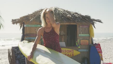 caucasian woman holding her surfboard