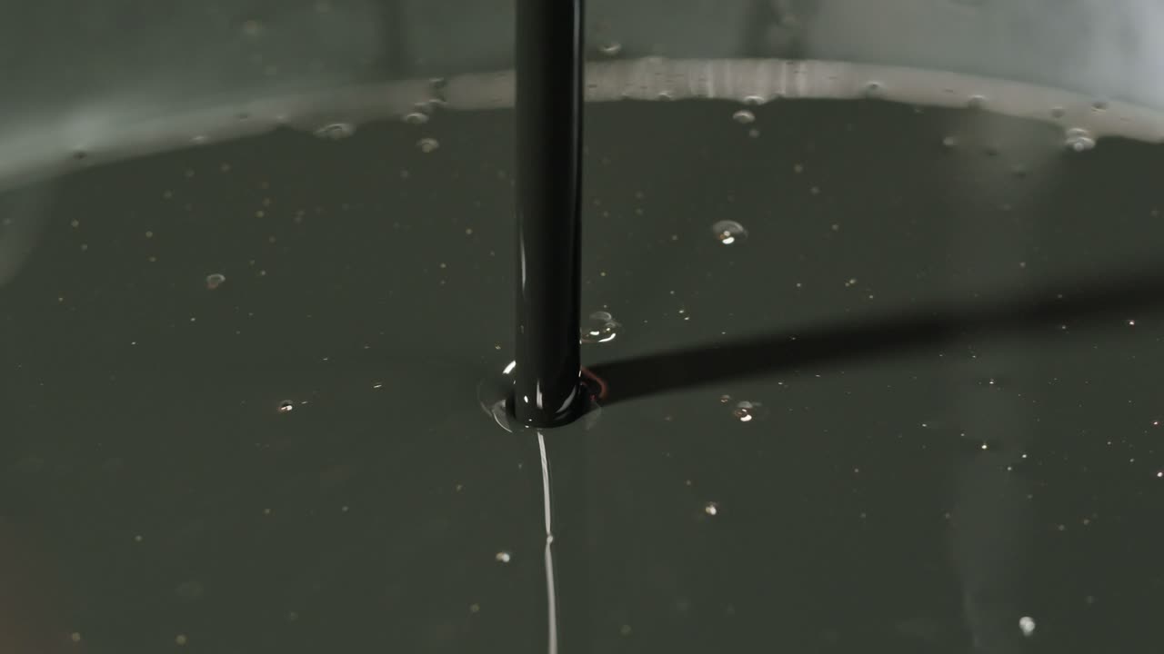 Dark Oil Being Poured into a Container