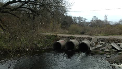 concrete waste pipes. streams of water flow through concrete pipes. polluted body of water in the park. shooting from the drone. aerial photography.