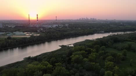 sun setting up behind vistula river power plant in poland, energetic concept