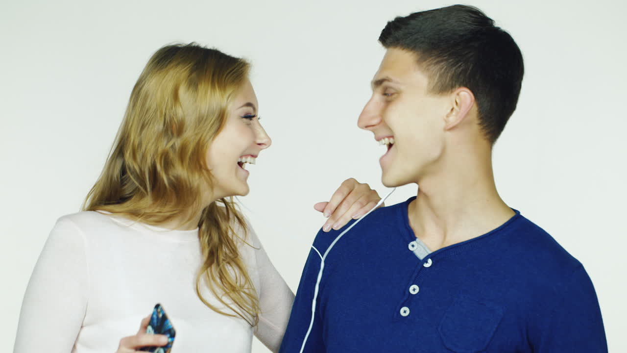 pareja joven escuchando música en auriculares y lúpulo video hd