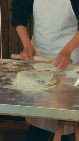 hands preparing dough at a bakery in wuzhen, china, with flour spread on a table
