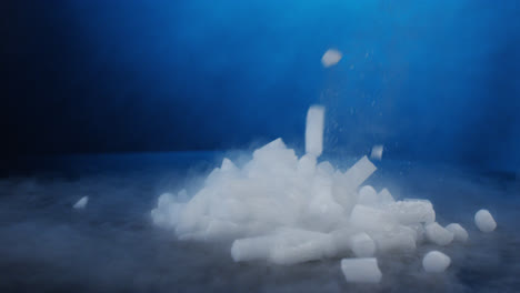 dropping a scoop of dry ice pellets on black table in slow motion with red camera