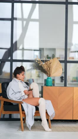 mujer relajándose con café y teléfono en un hogar moderno