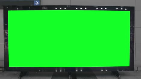 empty blank widescreen billboard with green screen, alpha channel. chroma key frame on airport hall, big banner for marketing.