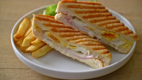 sándwich de jamón y queso con huevo y patatas fritas