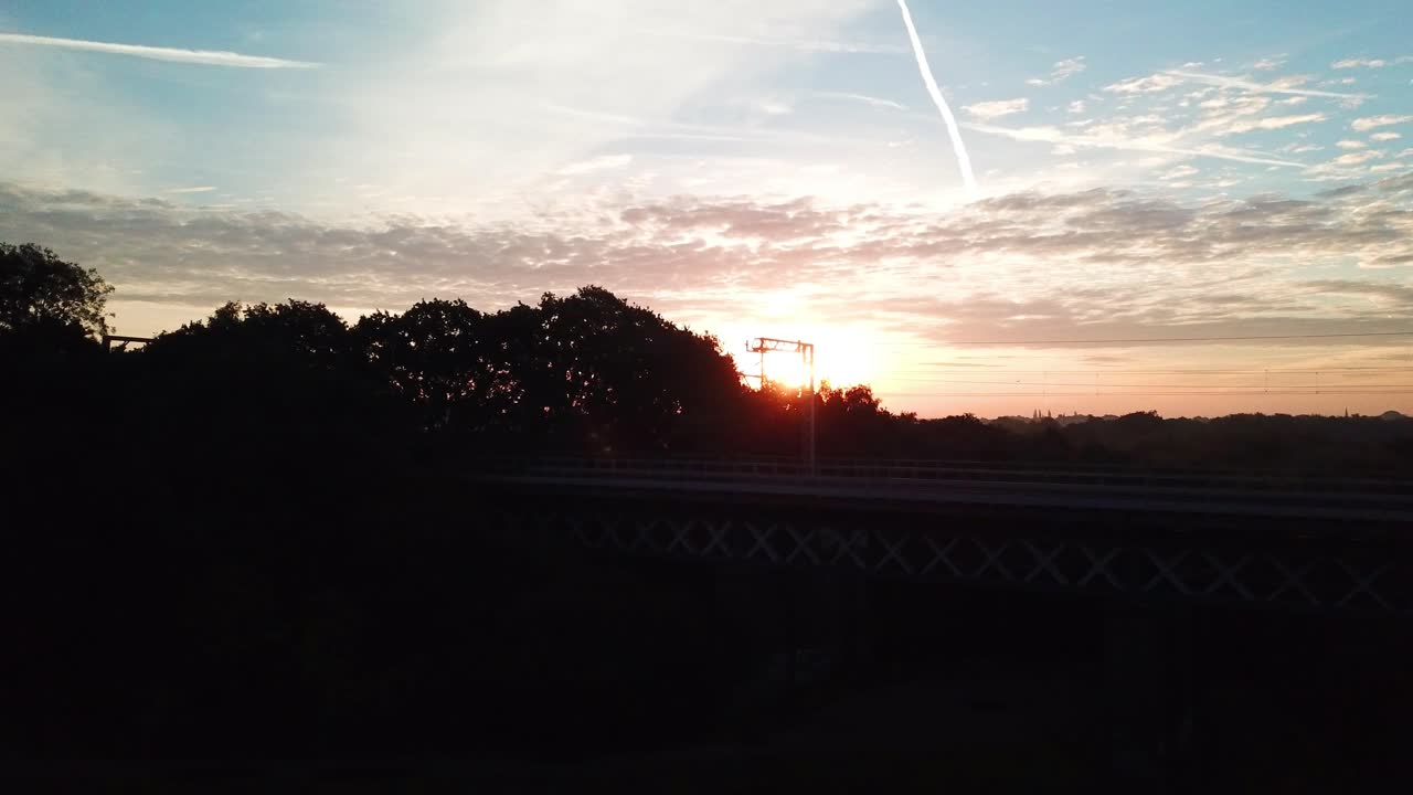 Horizontal panning aerial shot of rail bridge at sunset