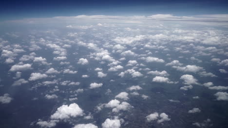 vista desde la ventana de un avión de pequeñas nubes blancas sobre el bosque
