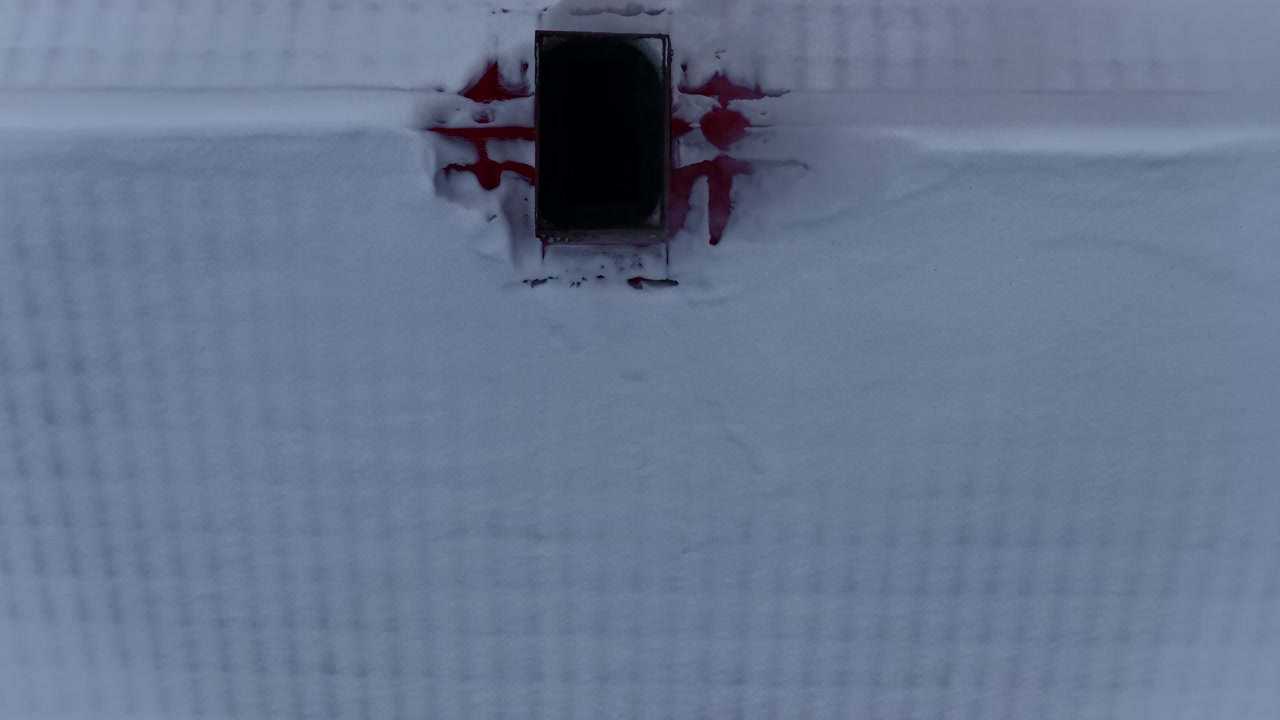 Above house roof covered in snow winter season, smoking chimney log wood heater