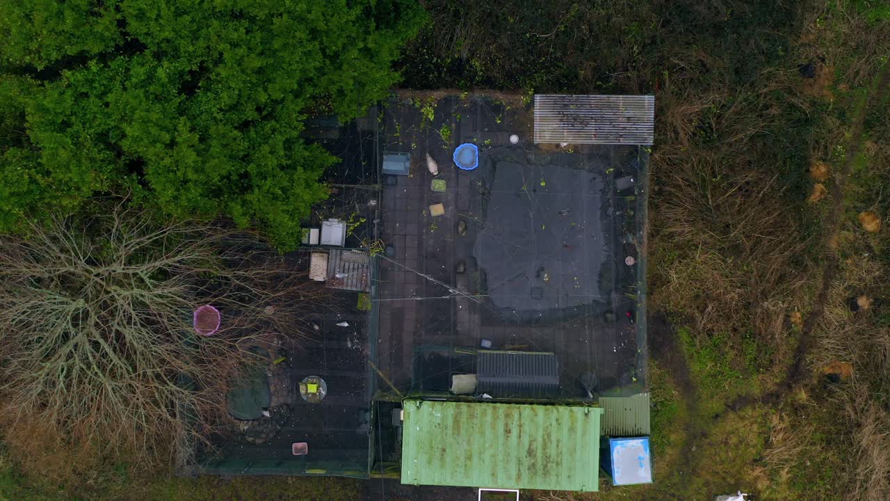 Top-down aerial descending over a bird sanctuary, showcasing sections under a netted roof