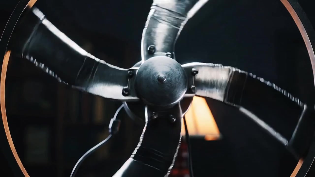 Receiving power via cord, five-blade fan spinning clockwise in study, lamp backlighting metal rim