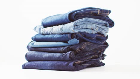 close up of folded jeans with different shades on white background with copy space