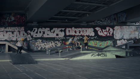 extreme man performing jump stunt on bmx bike at skate park with graffiti.