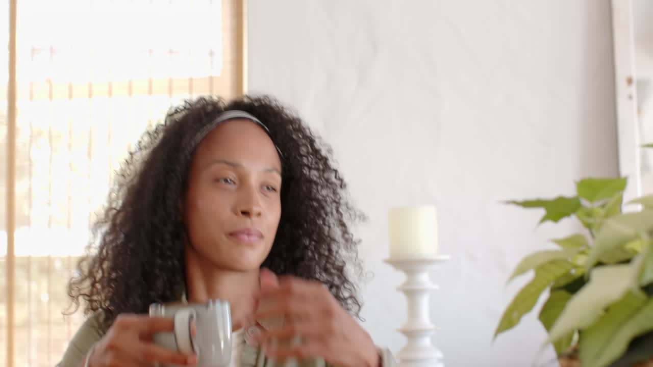 woman enjoying coffee at home, smiling and looking relaxed