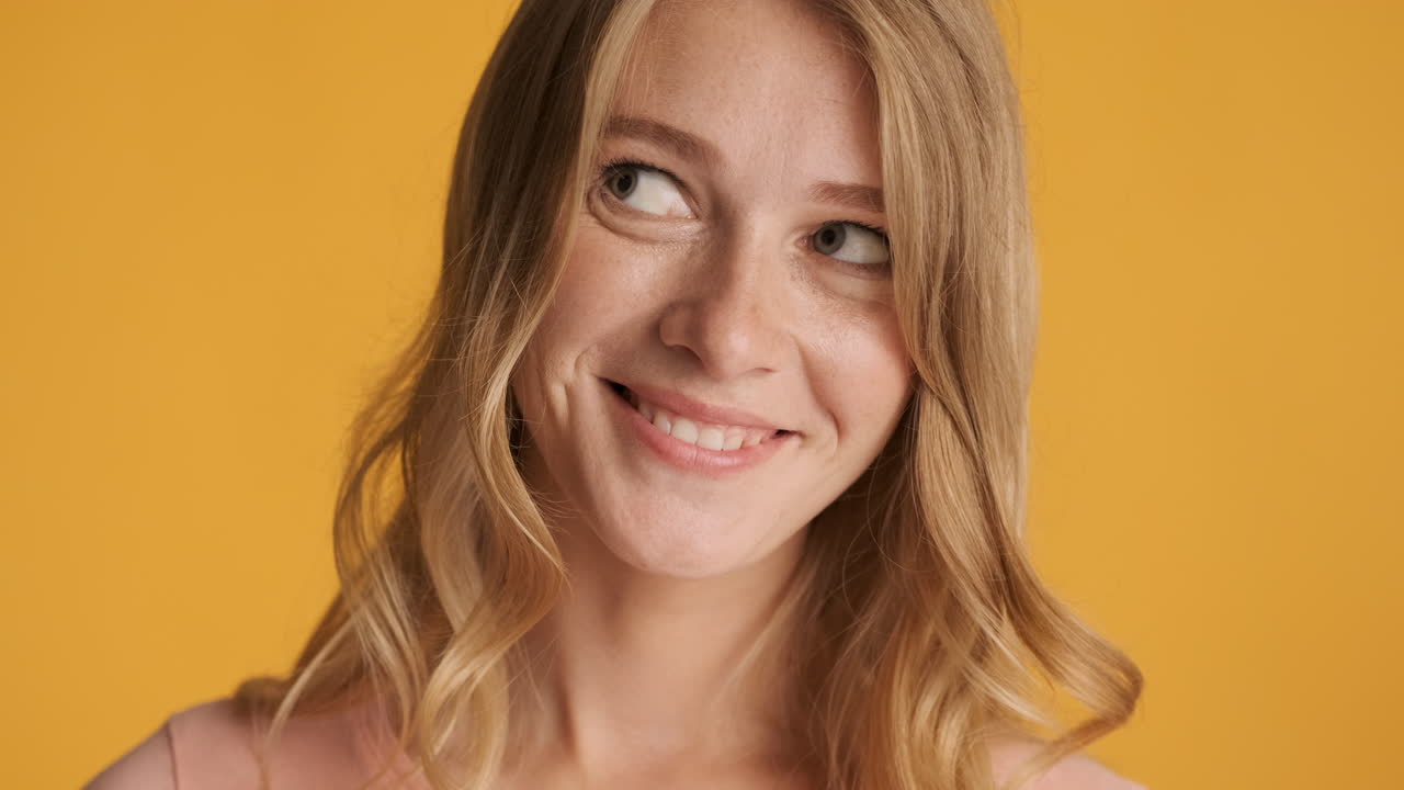 Caucasian woman raising eyebrow on camera.