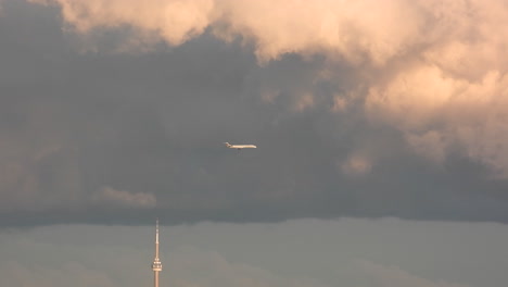 moody overcast cloudy sky with jetliner aircraft descending to land at airport in toronto canada - establishing shot